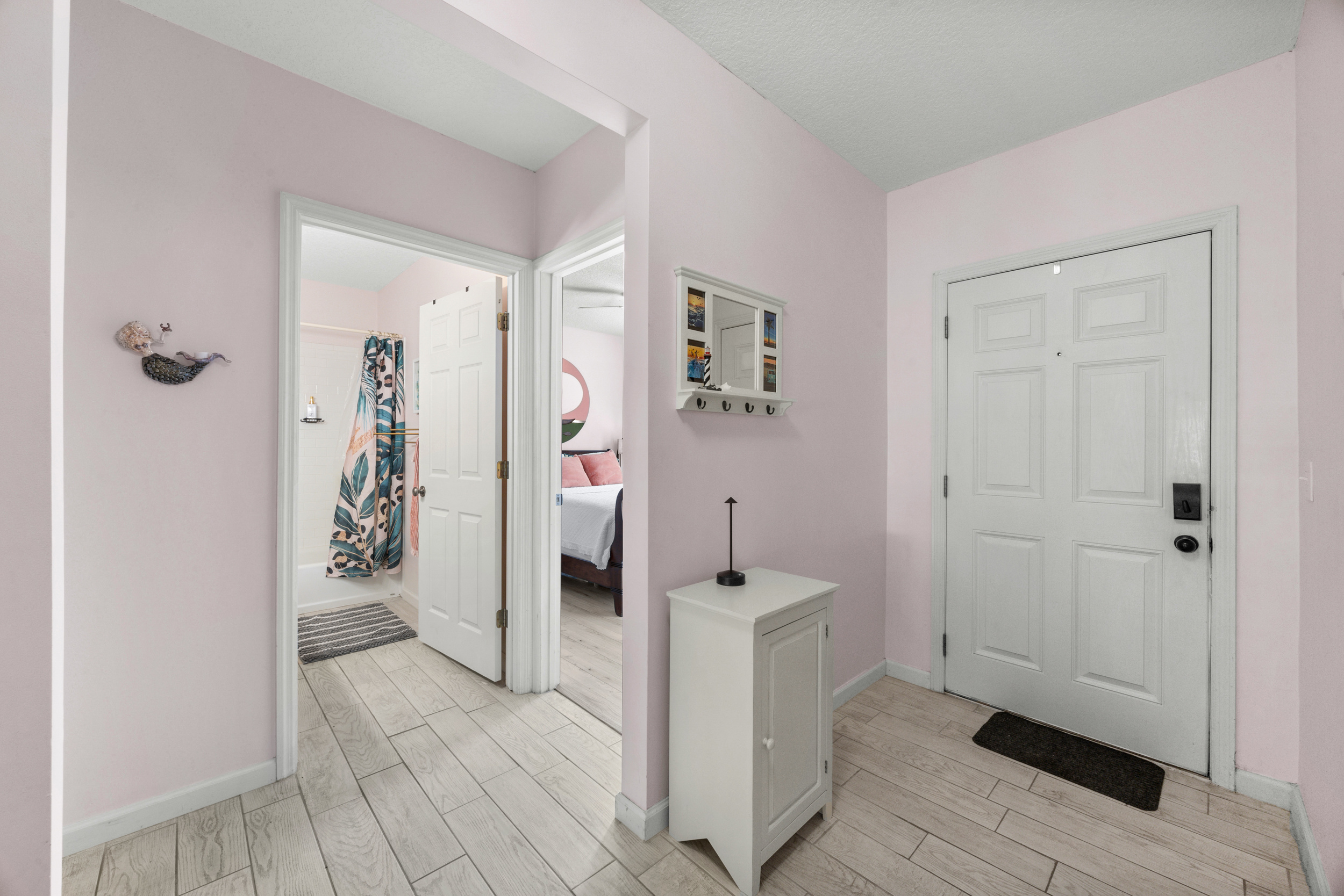 Clean, airy hallway connecting bedrooms and bathroom, accented with soft colors and thoughtful décor.