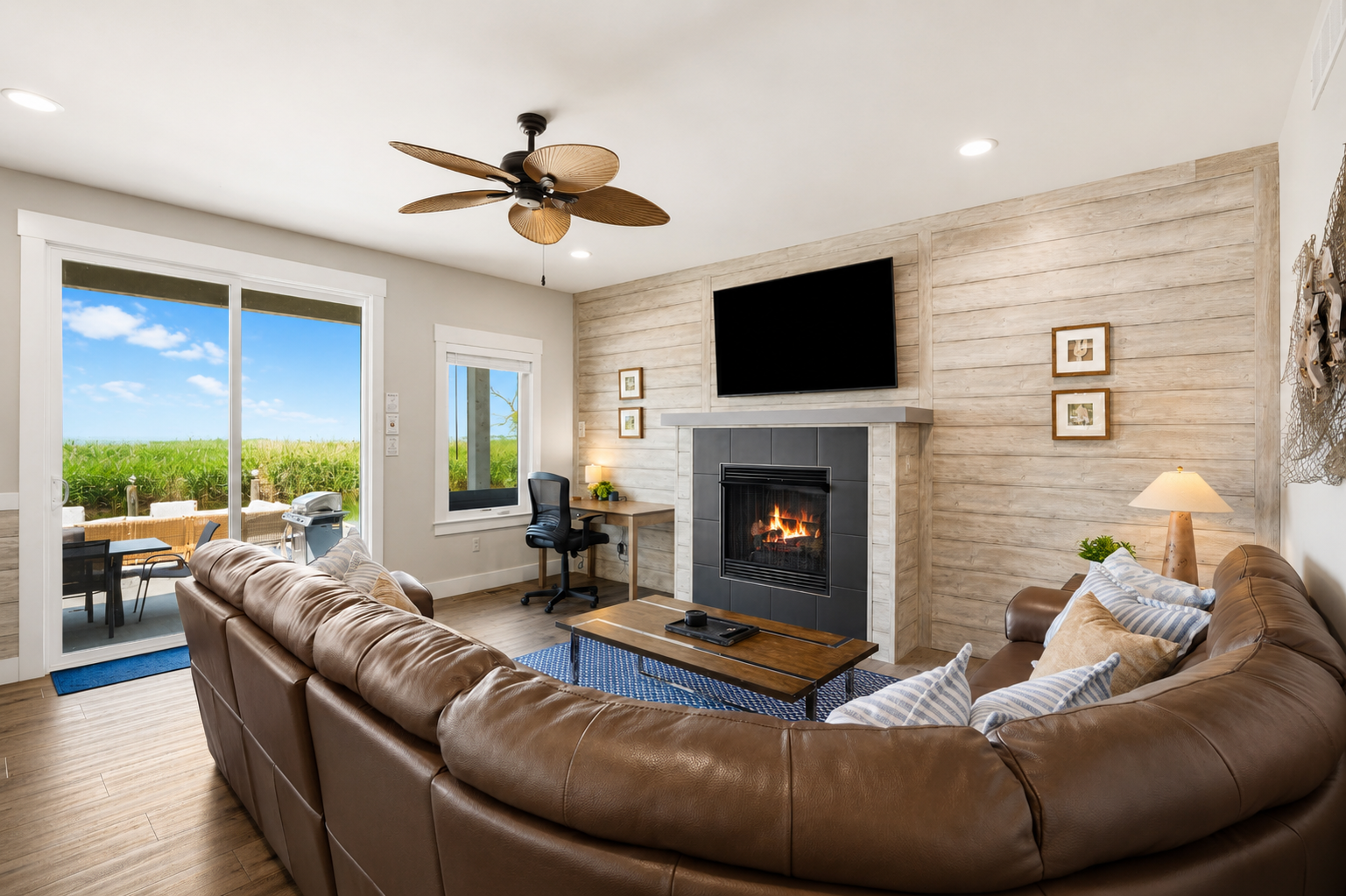 Gather in the spacious first-floor living room featuring a cozy fireplace, dedicated workspace, and stunning views of the backyard, canal, and Lake St. Clair. The perfect place to relax, work remotely, or unwind after a day on the water.