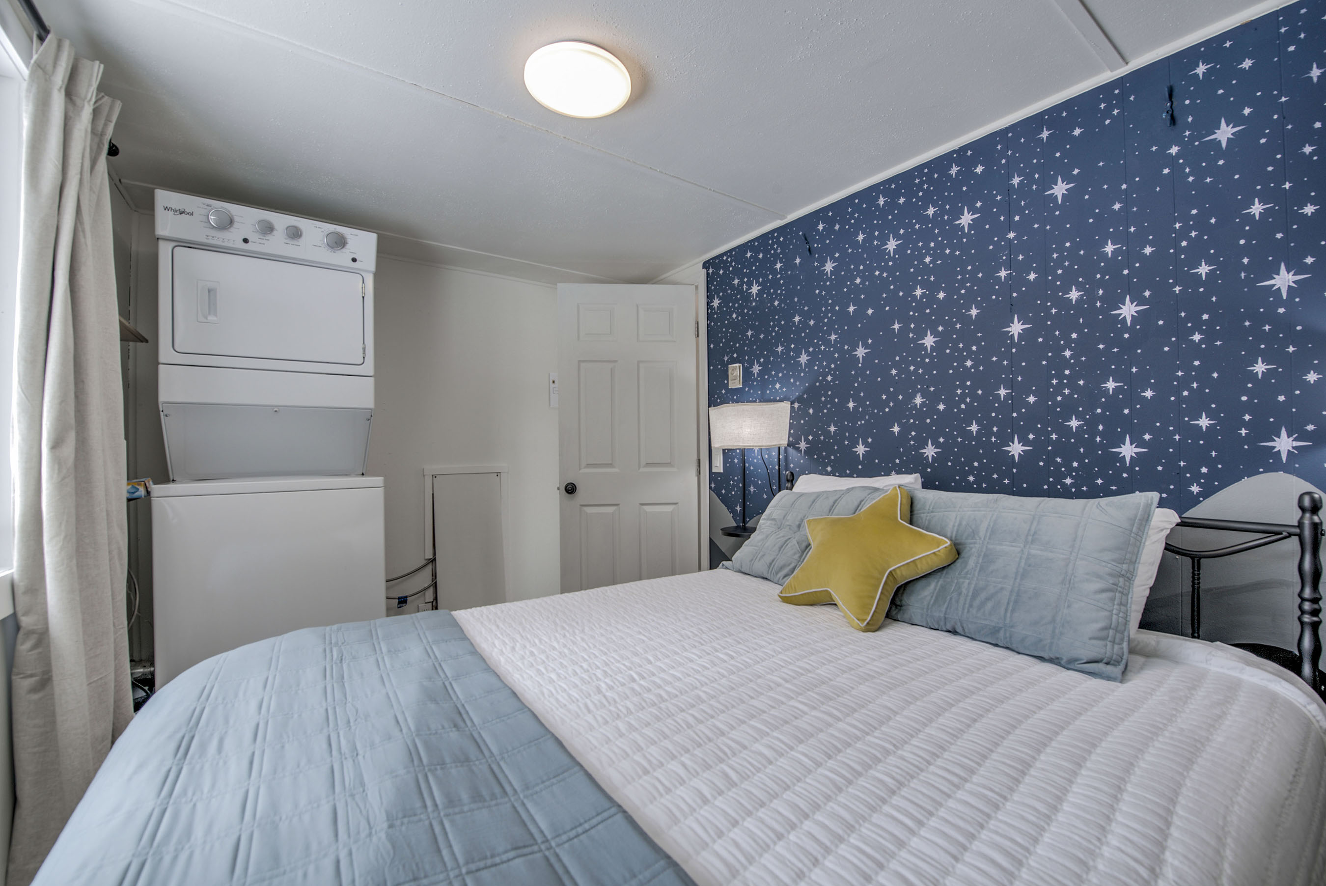 Rest easy in your cozy retreat—starry accent wall, soft linens, and added convenience make this space perfectly yours for a relaxing stay.