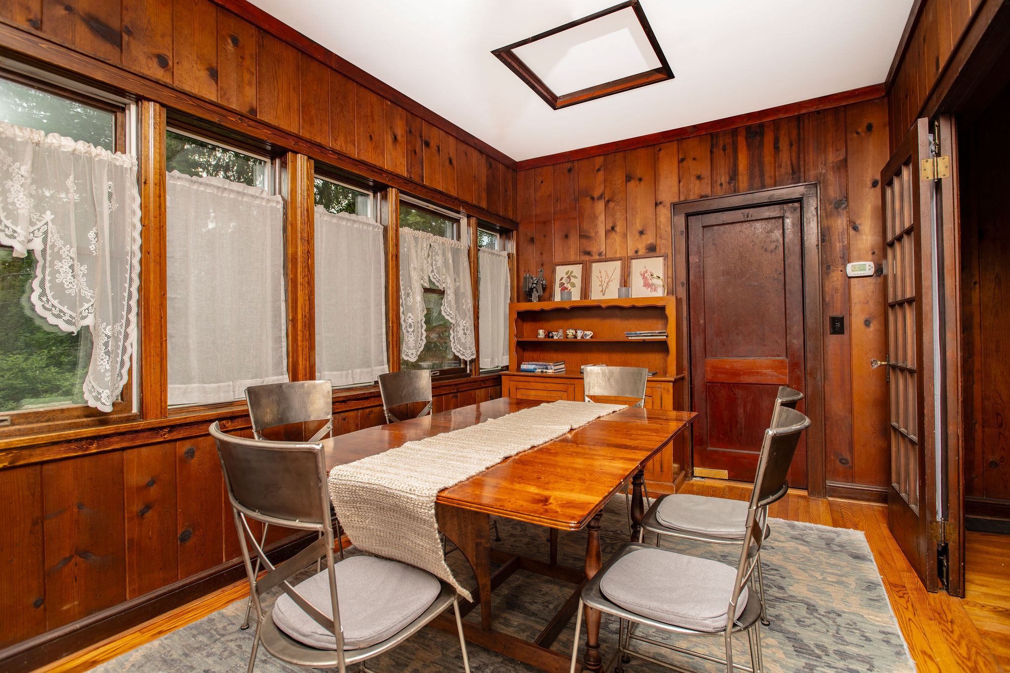 Dining room with vintage pine paneling and plenty of natural light