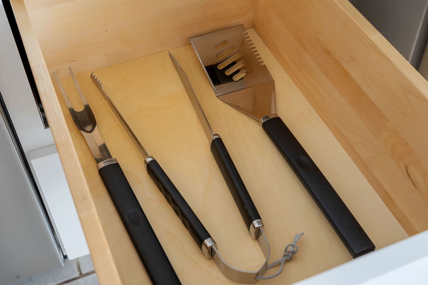 This drawer is equipped with quality barbecue tools, ideal for grilling enthusiasts. Everything you need for a perfect barbecue is within reach.