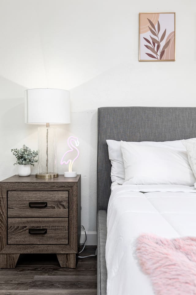 Add a little personality to your stay with a chic wood nightstand, a modern lamp, and a fun neon flamingo touch.

