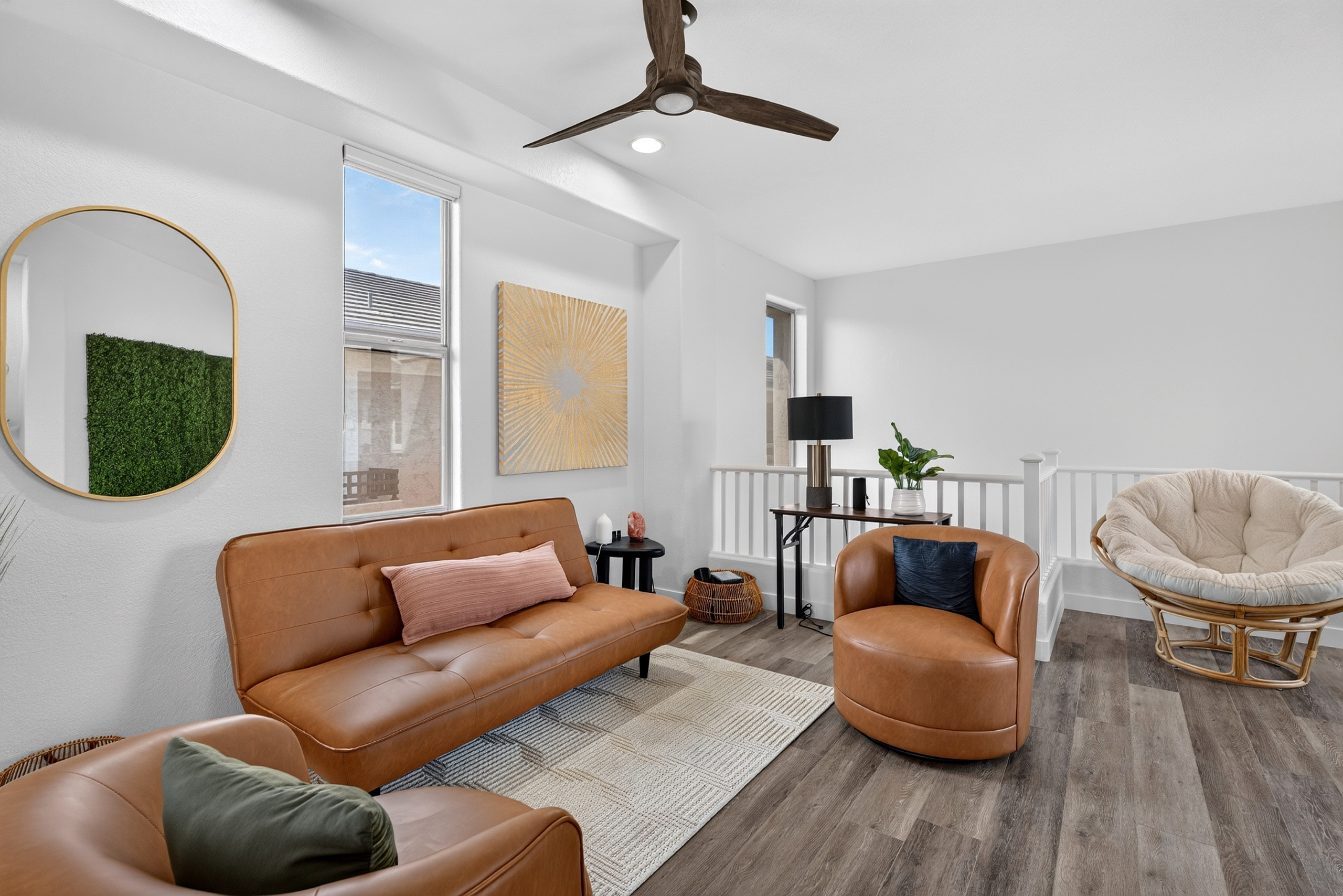 Open sitting area with accent chairs, sofa seating, natural light, and easy flow to the dining and living spaces.
