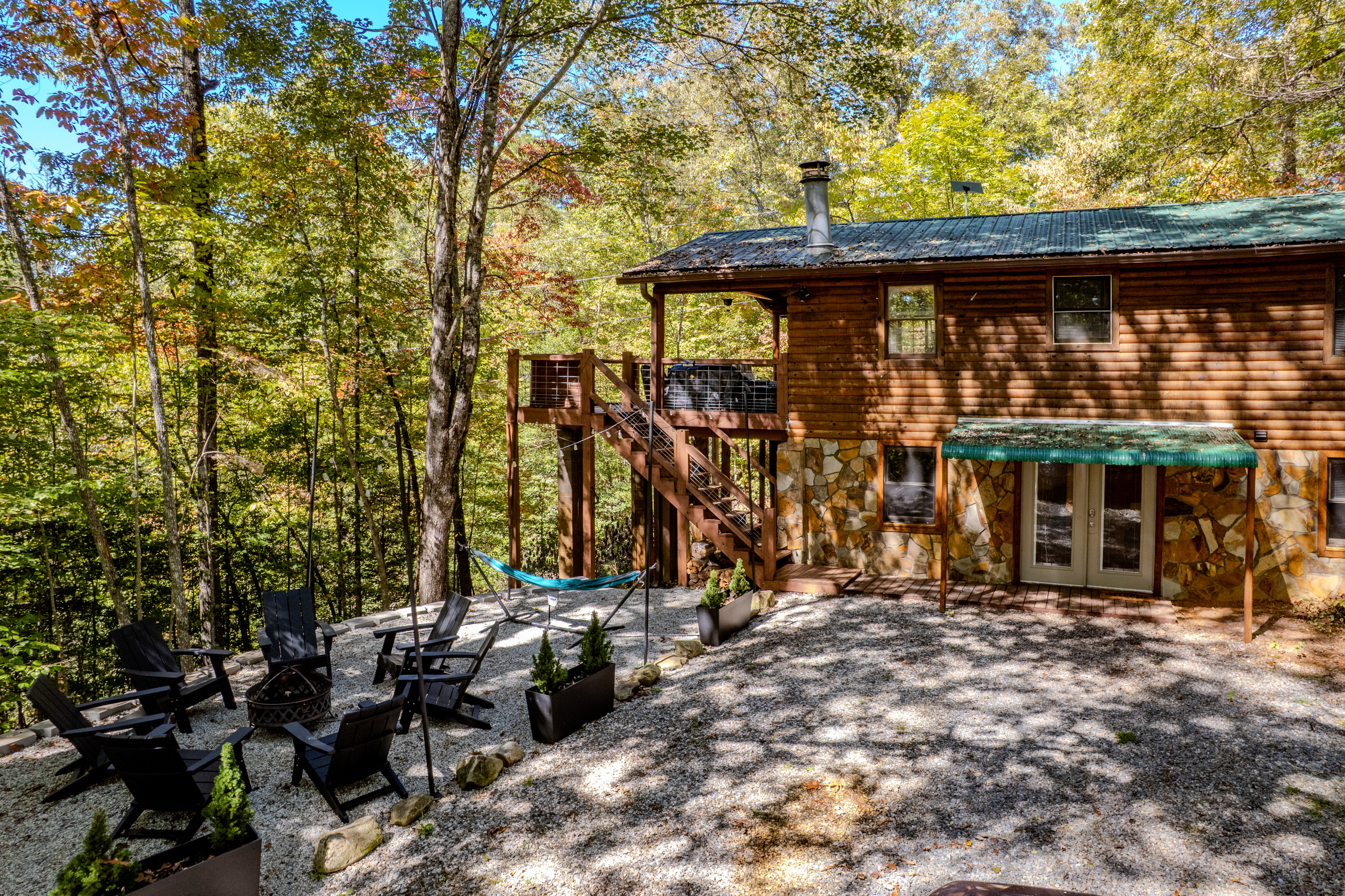 The side of the cabin from the driveway side. The french doors to the lower level are the access to the game room and 3rd bedroom. Please note there is no inside access from the main level to the lower level.