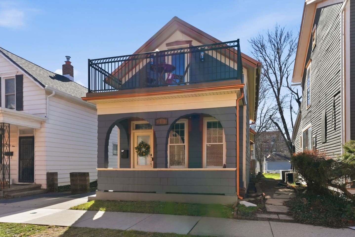 Bright and inviting curb appeal with classic architecture and a spacious balcony for outdoor lounging