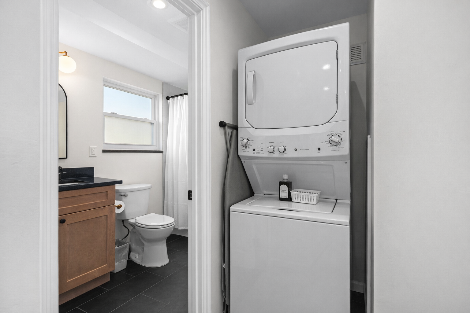 Convenient in-unit laundry beside a clean, modern bathroom—making longer stays easy, comfortable, and stress-free.
