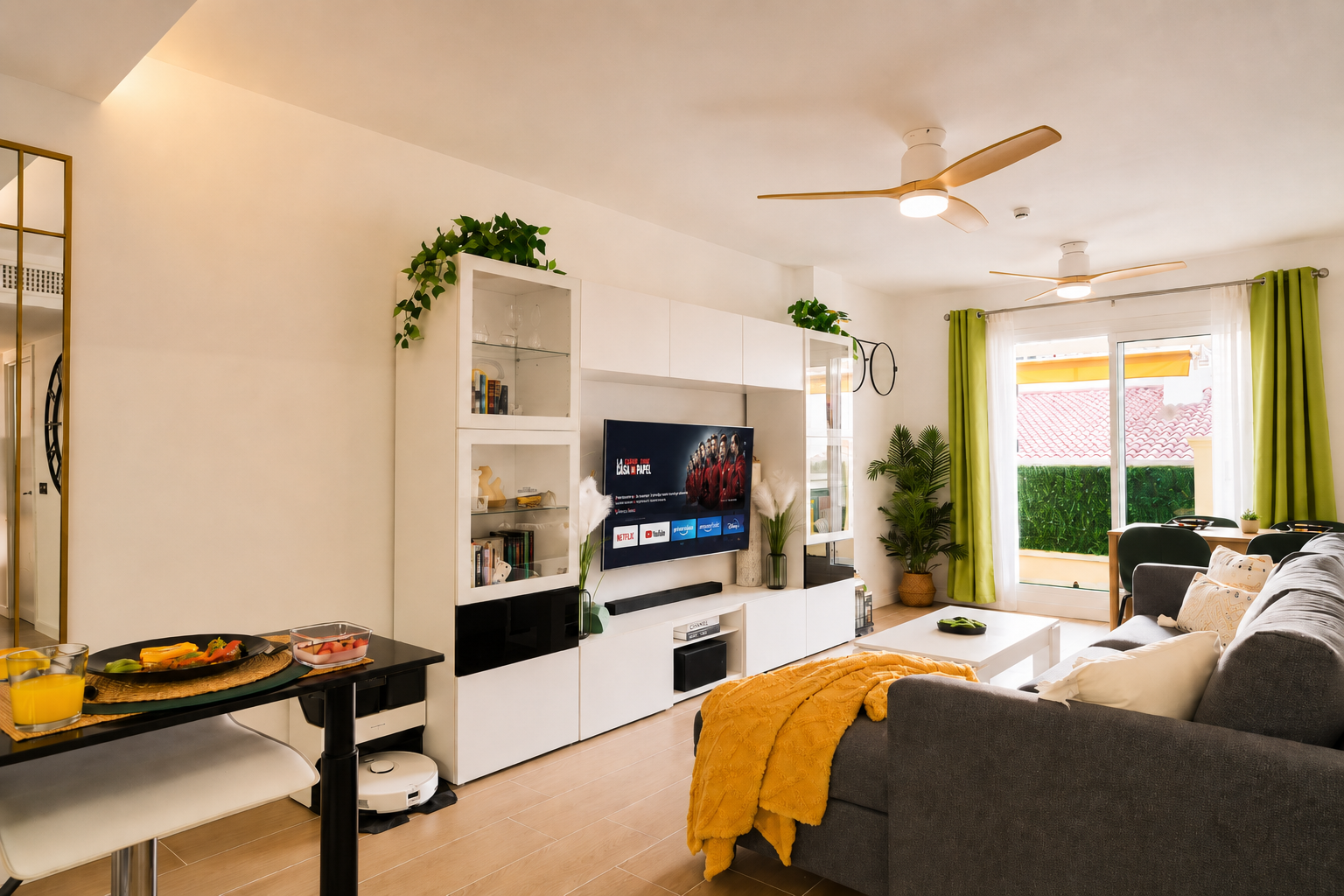 Stylish open-plan living room with a modern kitchen, smart TV, and natural light throughout — ideal for relaxing or sharing a glass of wine after a day by the beach.