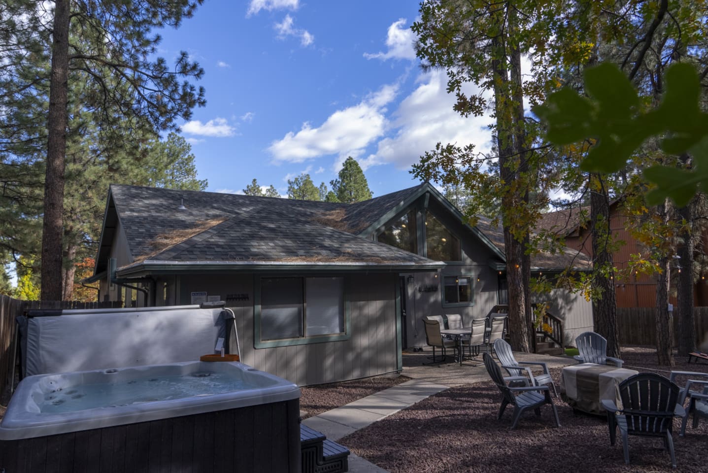 Backyard setup with hot tub, fire pit area, and plenty of seating for relaxing outside.