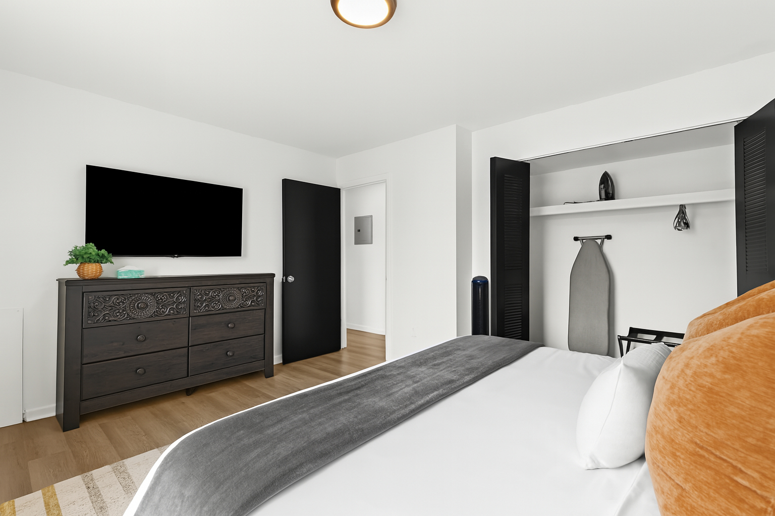 Enjoy restful nights in this calming bedroom with ambient lighting and a king bed against a wood feature wall.