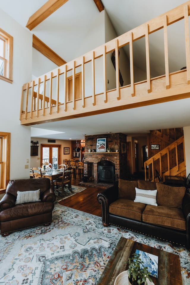 Living room looking towards the dining area and kitchen with the third floor loft above. Note that the wood stove is no longer available.