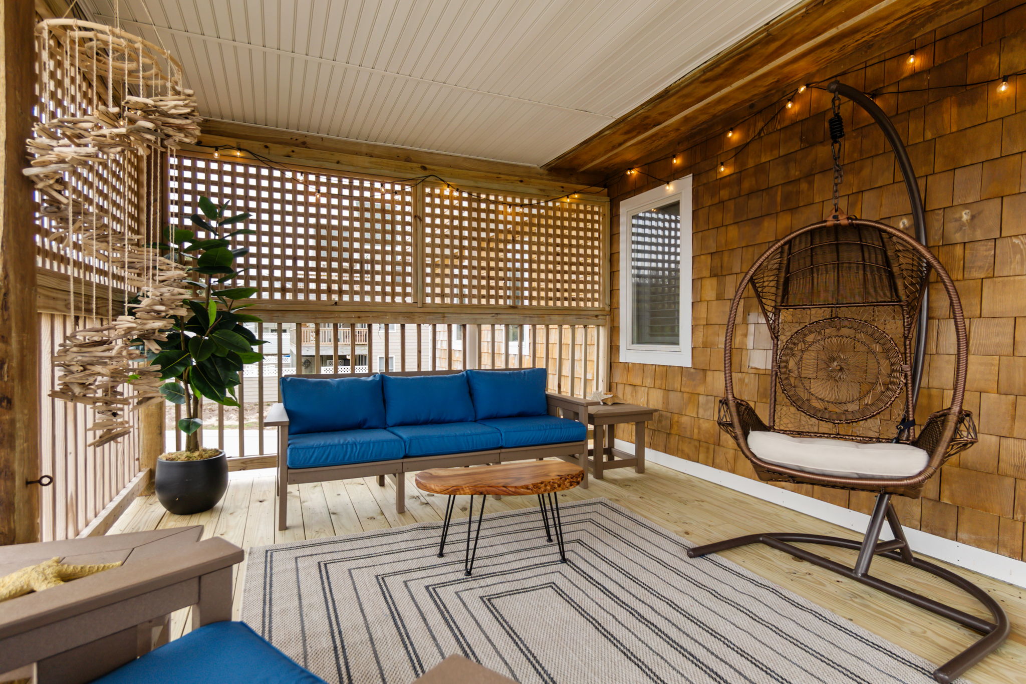 Another angle of the screened porch, showing the cozy seating and layout.