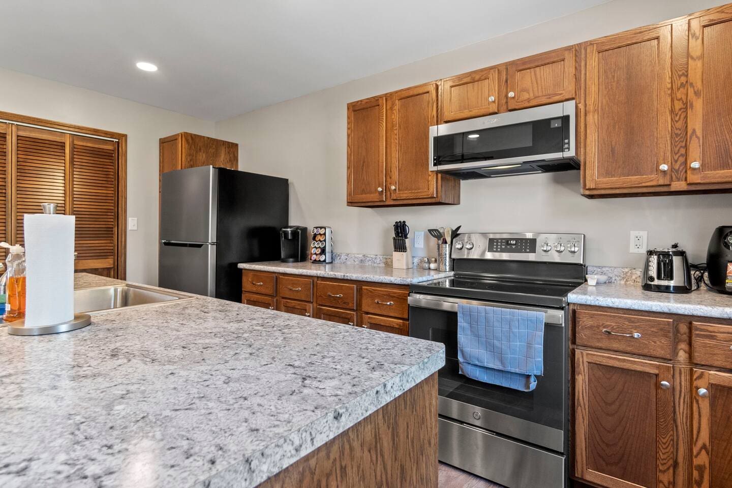 Kitchen showcasing sleek modern appliances, including a stove, fridge, and microwave, designed for both style and functionality.