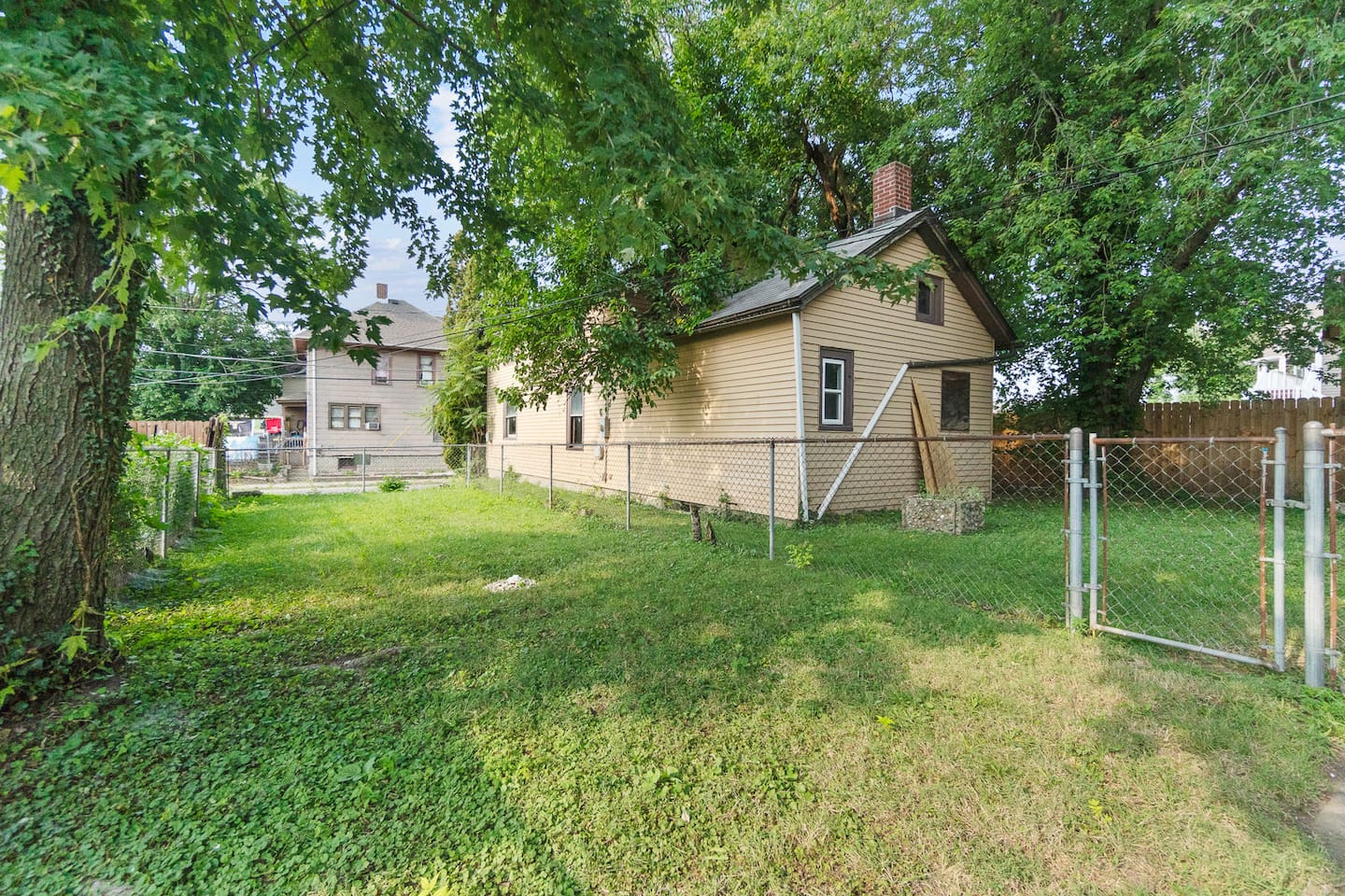 Back exterior of the house surrounded by trees.