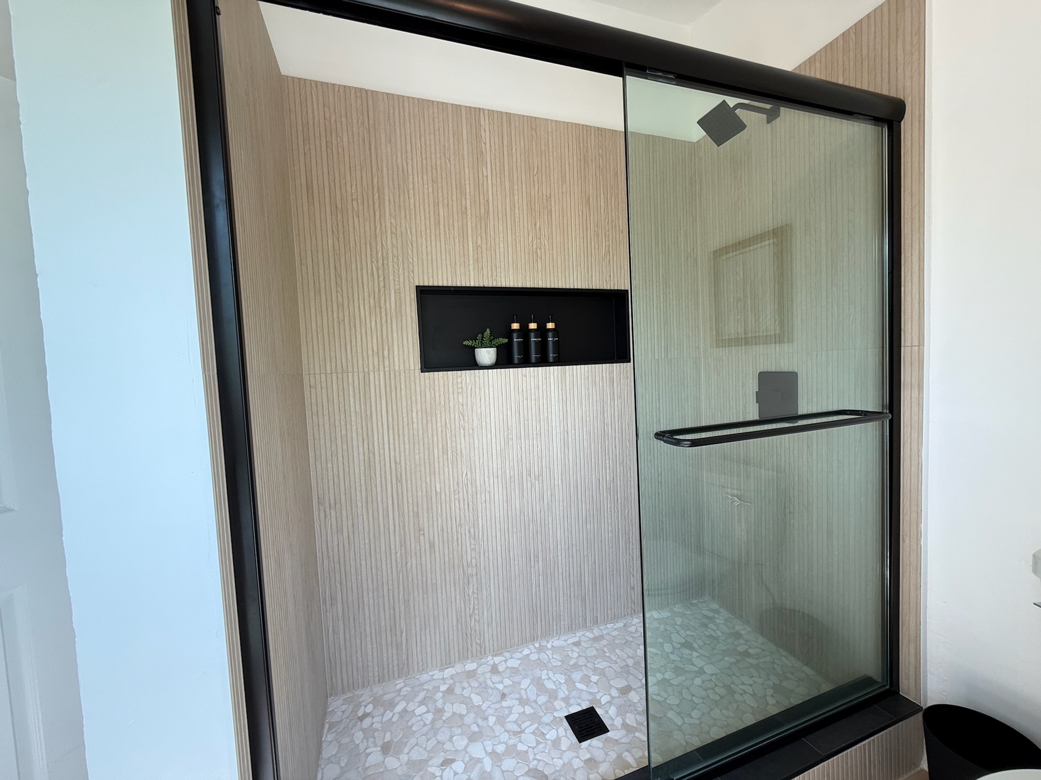 Modern beachy shower in the main level master bathroom. Lots of natural light from the oversized window
