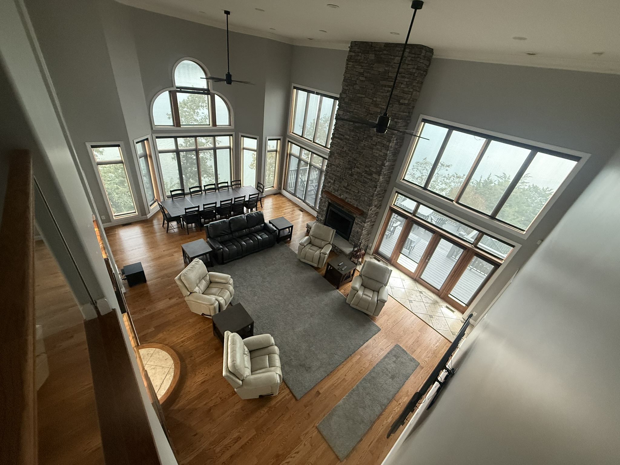 Living room with 20 ft ceiling, large windows with full view of Douglas Lake and Mountains on multiple sides, with doors to 2 porches (one out back and one next to the kitchen)