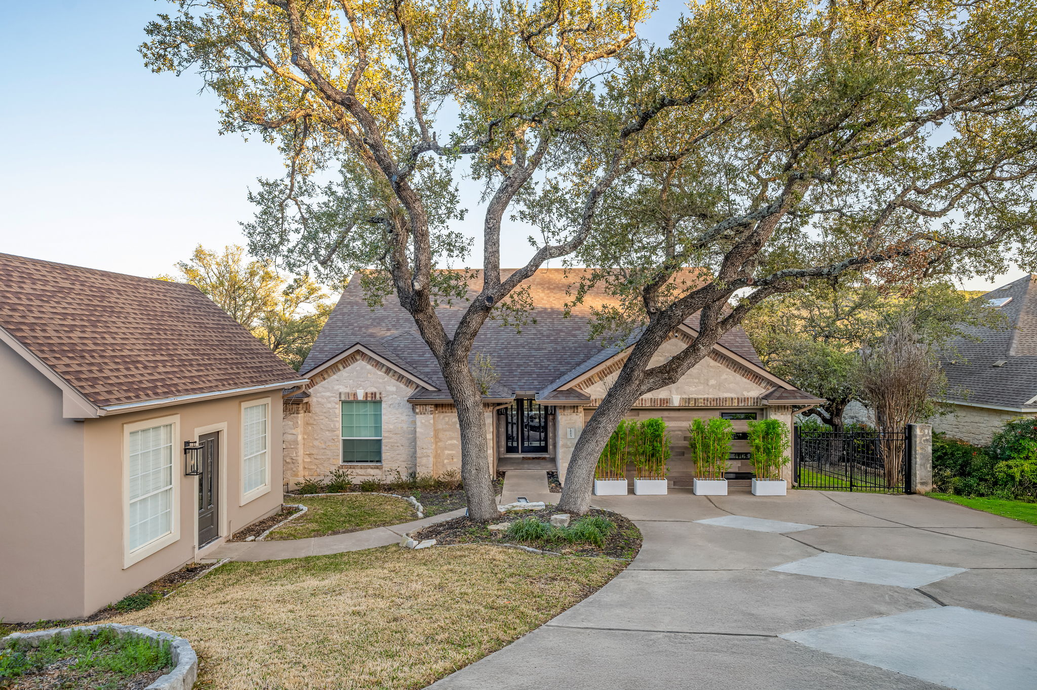 Peaceful front driveway shaded by mature trees with plenty of parking space.