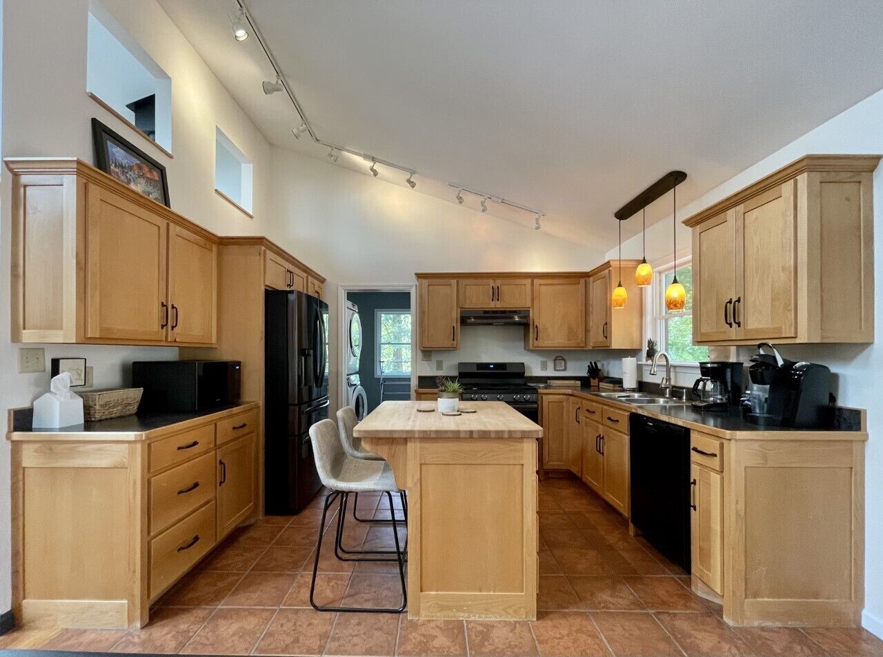 Fully stocked kitchen has new appliances,  door goes to the laundry, & back door