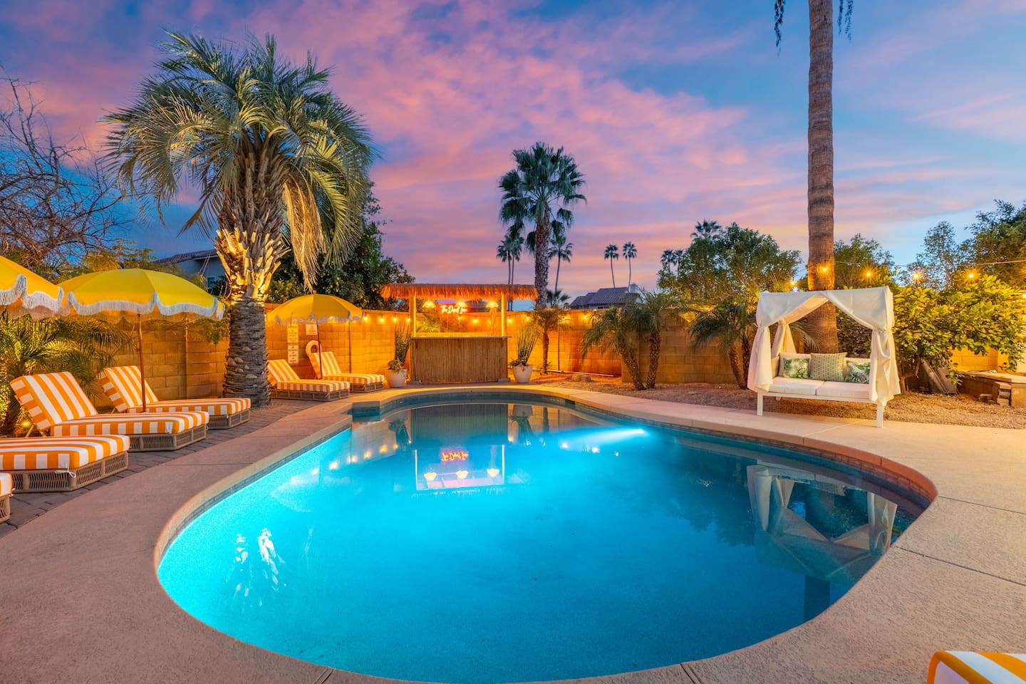 Resort-style pool at sunset with loungers, umbrellas, and desert views—your private oasis for swimming and stargazing.