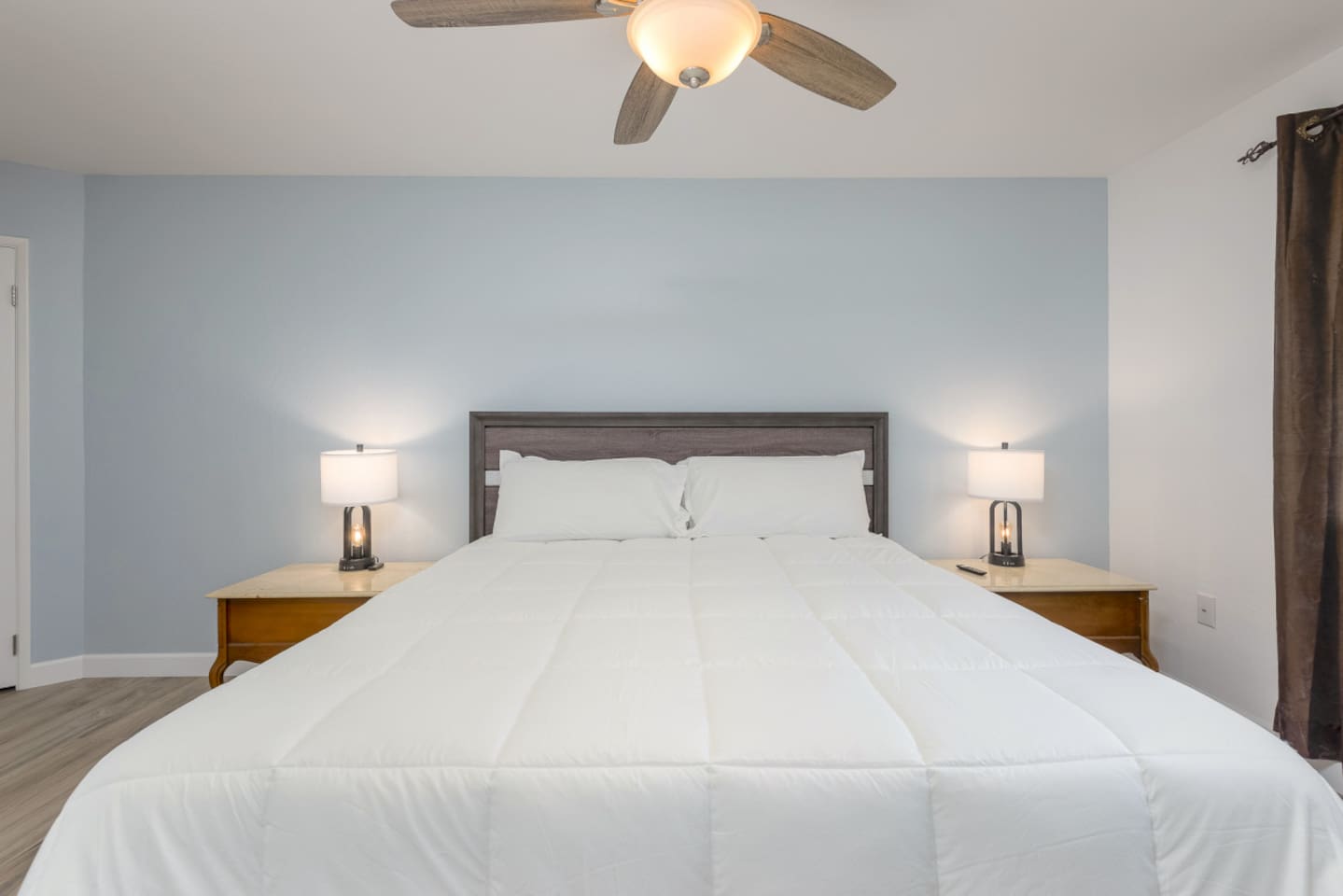 King bedroom with soft bedding, bedside lamps, and a simple place to relax at the end of the day.
