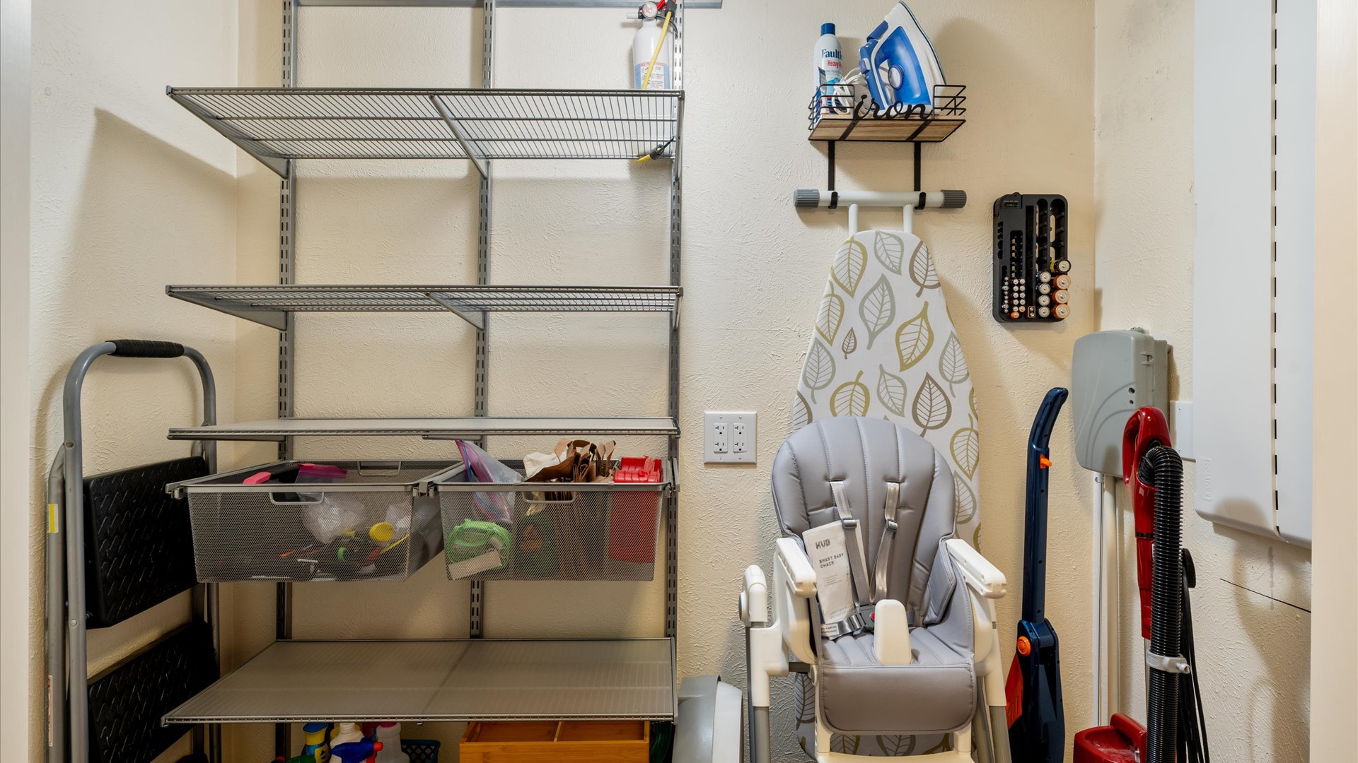 A spacious pantry for guests to store their dry goods and kitchen essentials. Well-organized with plenty of shelving, it also holds useful extras like a high chair, ironing board, and cleaning supplies—offering convenience and flexibility during your stay!