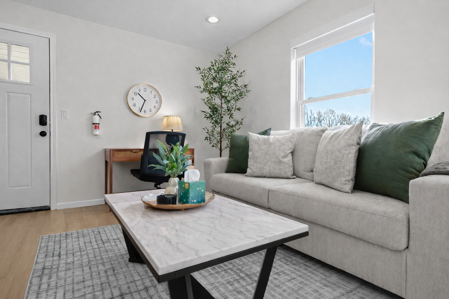 Bright, inviting living room with plush seating, natural light, and a dedicated workspace—perfect for relaxing, working, or enjoying a cozy night in.