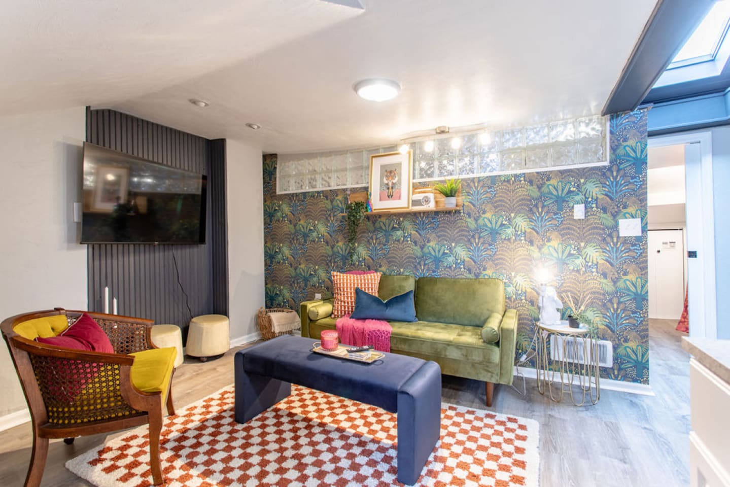 Step into this chic and vibrant living room, designed for ultimate comfort and relaxation. Sink into the stylish seating, catch up on your favorite shows on the 55-inch Roku TV, and enjoy the unique, colorful decor that adds a touch of flair. The roo
