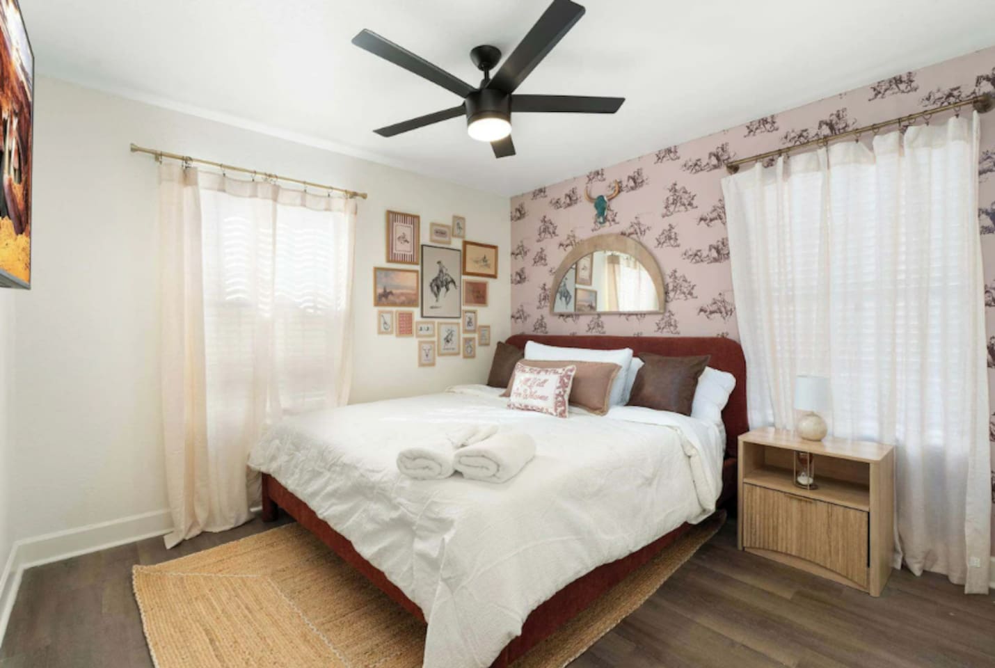 Cozy guest bedroom with burgundy headboard, patterned wallpaper, and natural light—intimate and inviting with vintage charm.