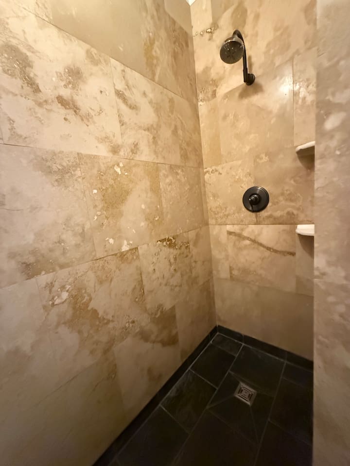 Travertine tile walk in shower. So beautiful we replicated it in the other townhouse.