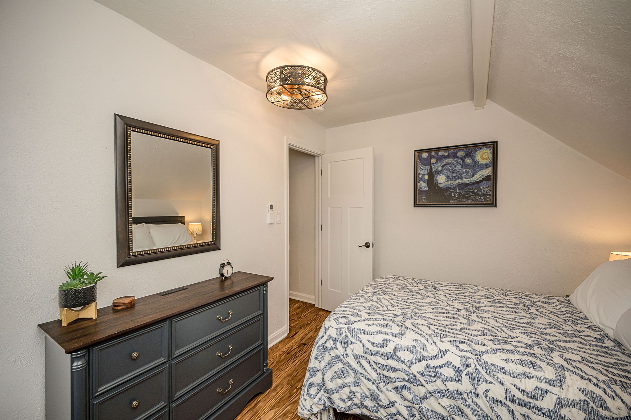 Another view of the upstairs queen bedroom with dresser and closet.