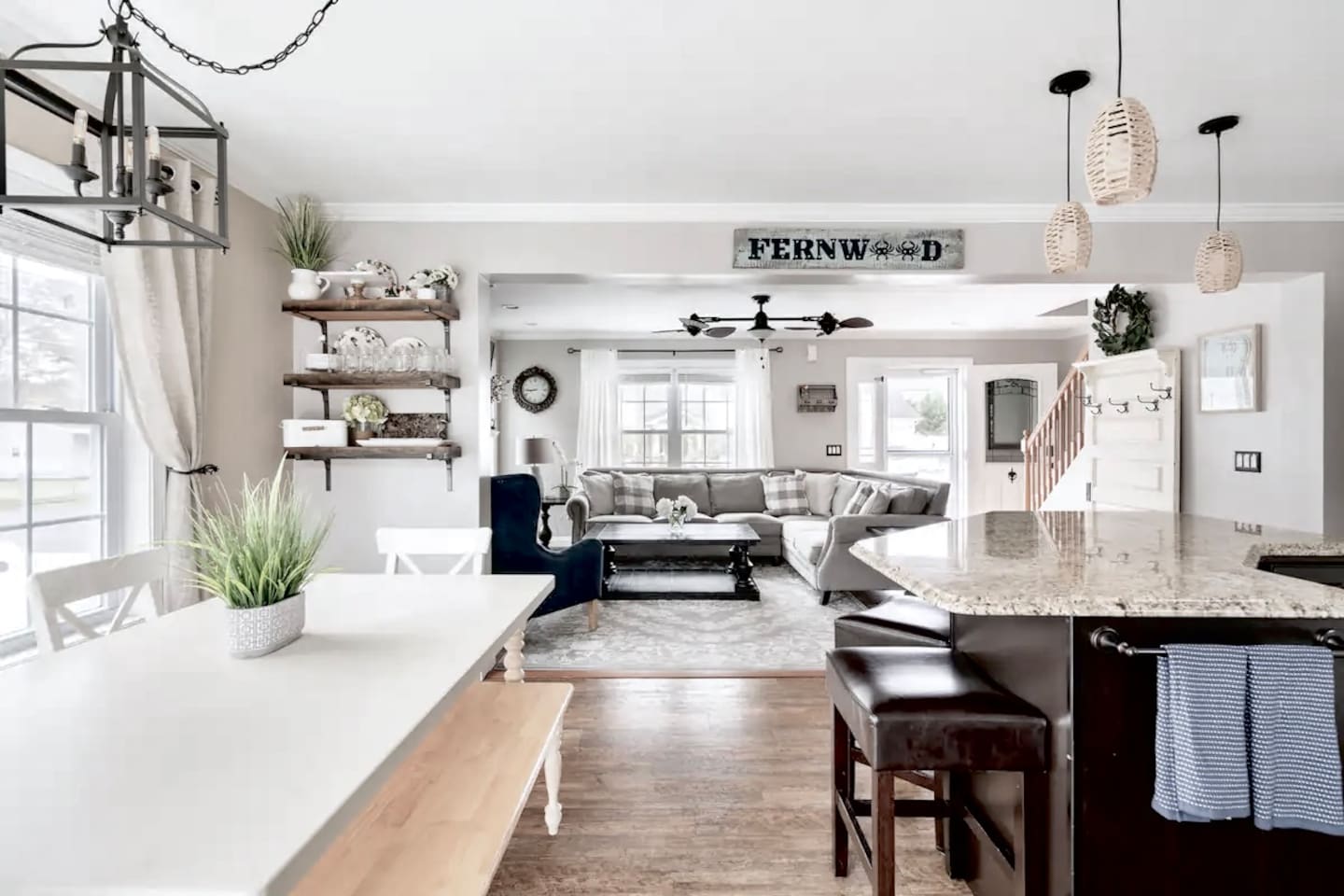 This open-concept layout connects the dining area, kitchen, and living room, making it perfect for socializing. The space features stylish pendant lighting, rustic shelving, and a bright, airy feel that flows throughout the main floor.