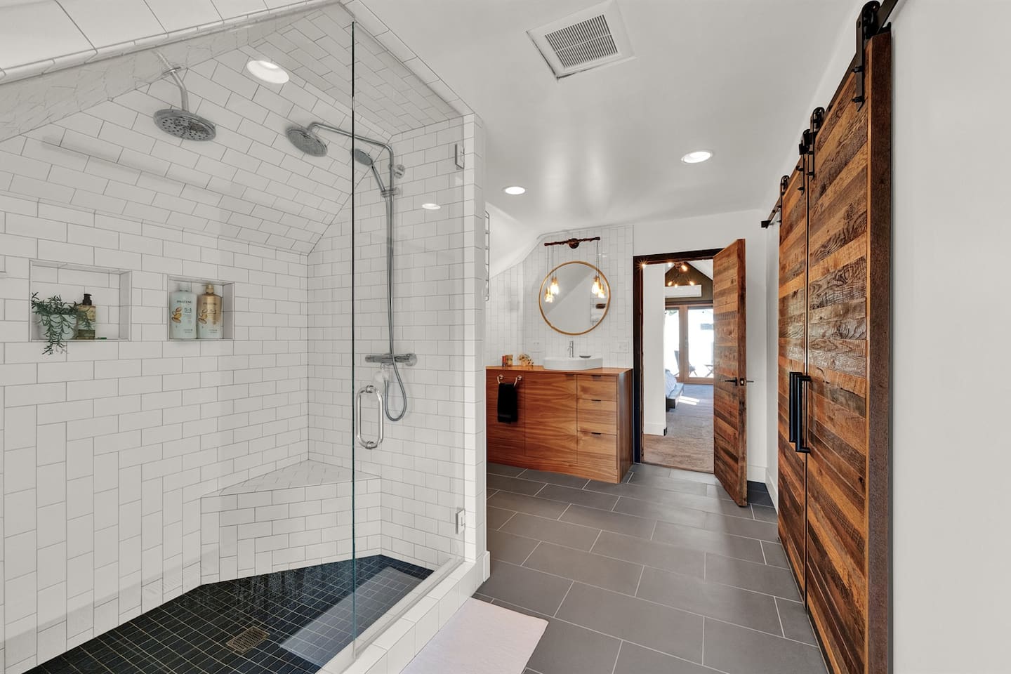 Unwind in the spacious primary suite, featuring an en suite bath and oversized closet with charming barn doors — comfort with a touch of rustic elegance.