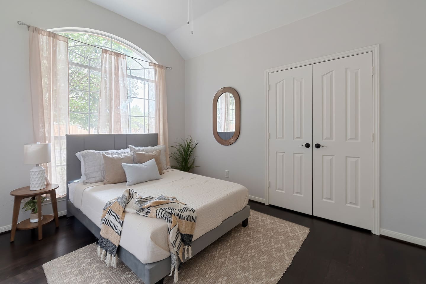 Inviting bedroom featuring two cozy double beds, adorned with plush pillows. A stylish wall mirror adds a touch of decor, complemented by a spacious closet for organization. Natural light streams through the window creating a tranquil atmosphere.