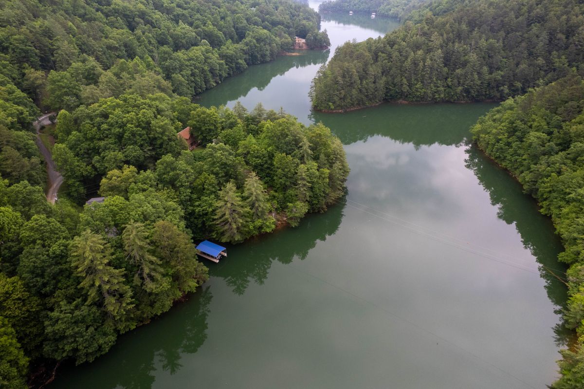 Lakefront Retreat: Stunning views await from this serene escape nestled among lush greenery!