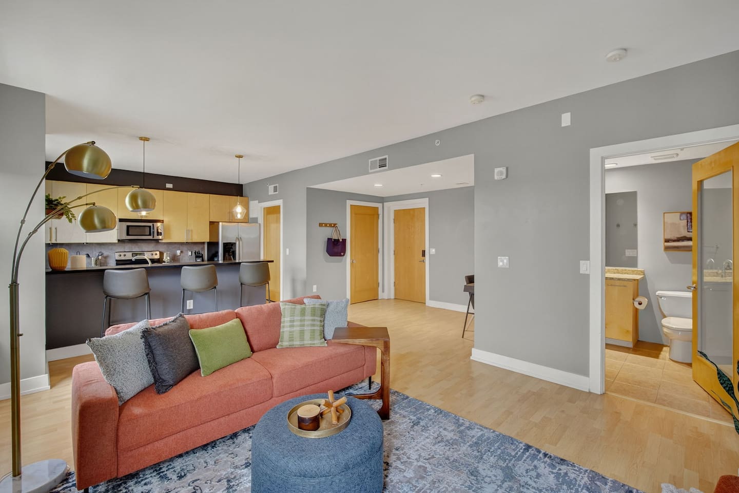 Enjoy an open-concept design with a vibrant sofa, cozy lounge seating, and direct access to a sleek kitchen and bath. Perfect for relaxing after exploring downtown Des Moines or gathering with friends over drinks.