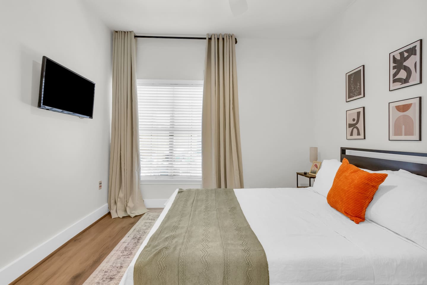 Bedroom with queen bed, TV, room darkening shades and large window views.