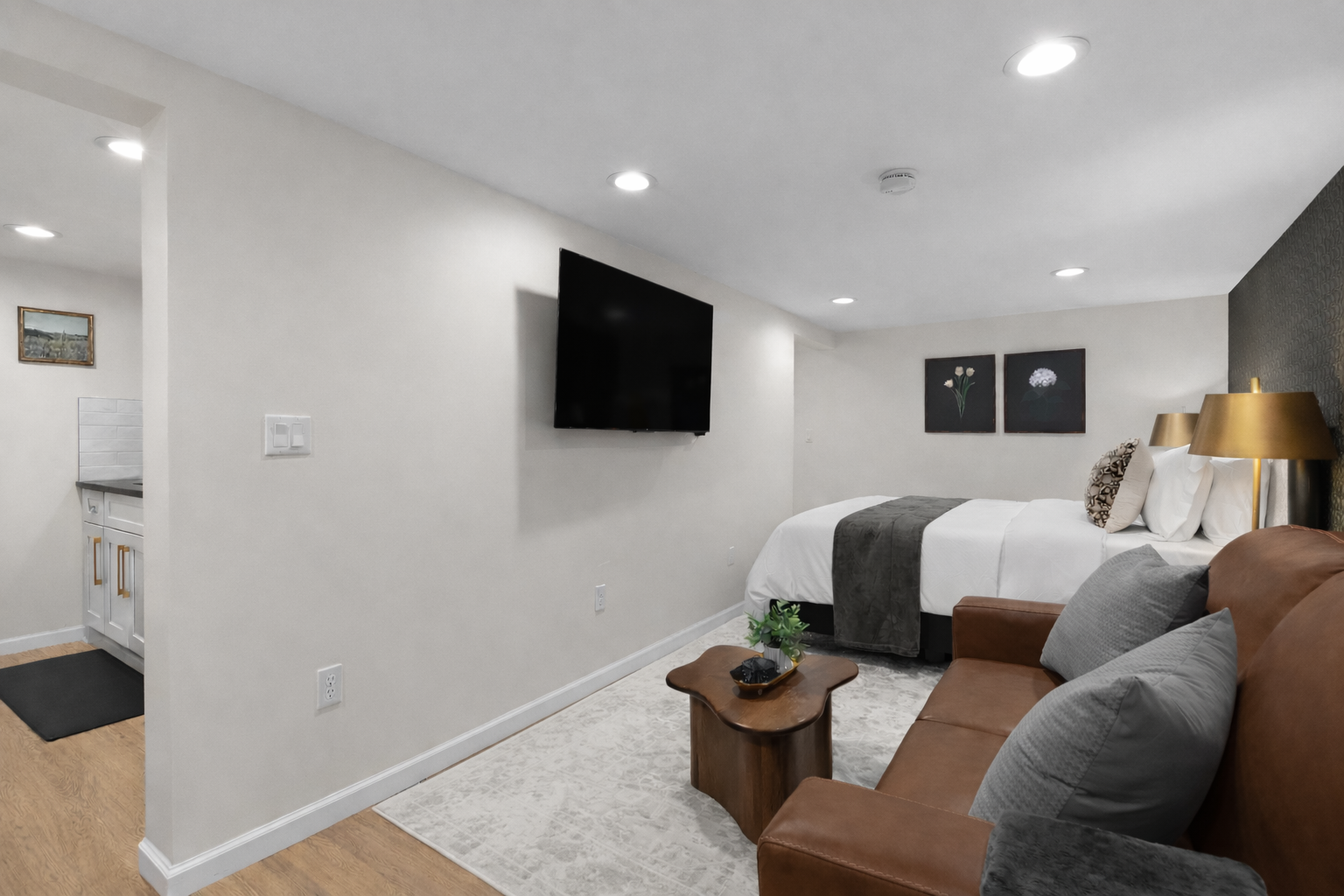 Inviting studio-style layout with a plush bed, cozy seating, and wall-mounted TV—designed for comfort, relaxation, and an easy, enjoyable stay.