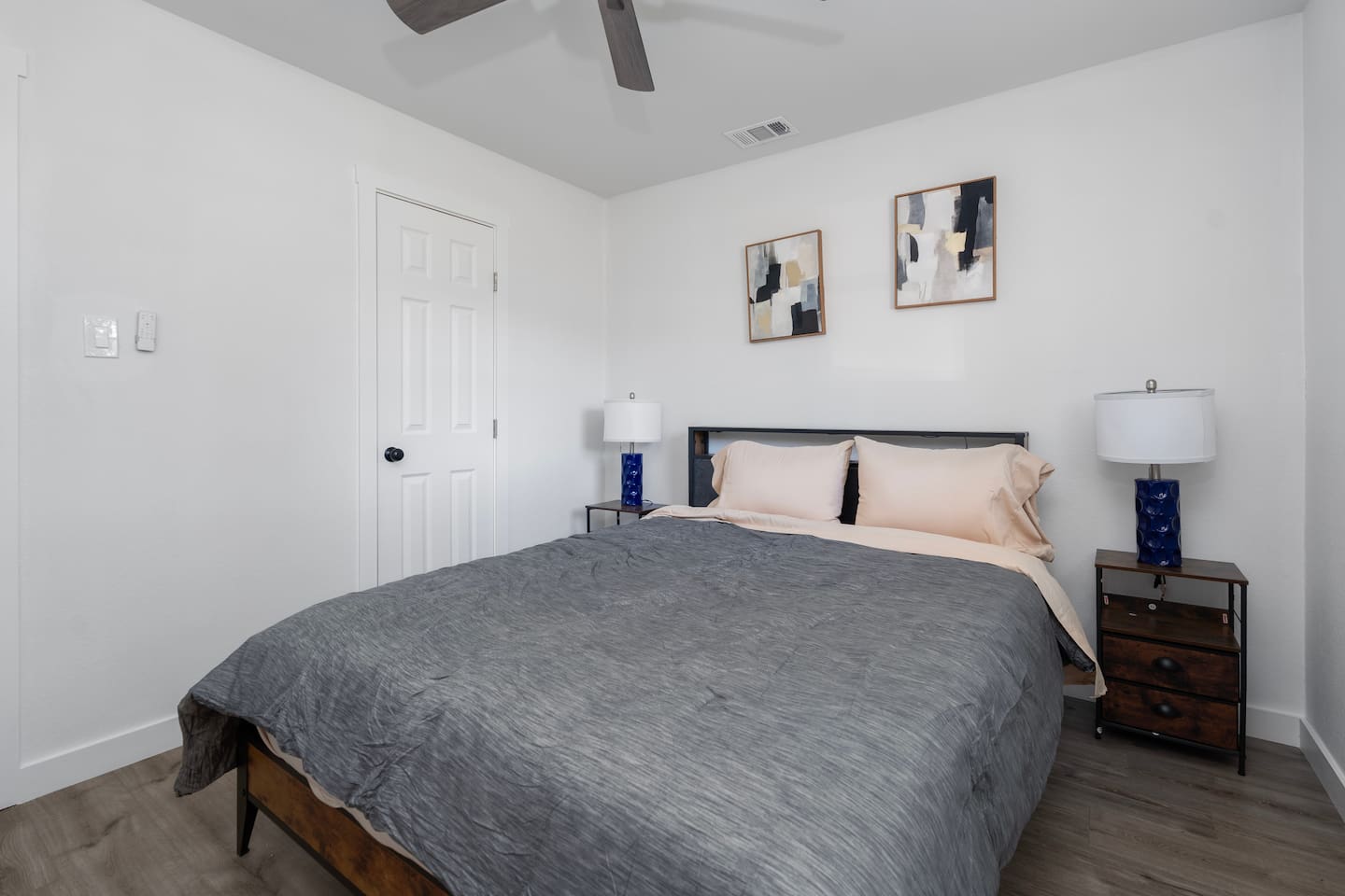 Queen bedroom with plush bedding, a ceiling fan, plenty of natural light and room darkening shades.