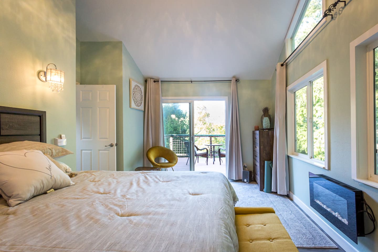 - Master bedroom with king bed, modern electric fireplace, and balcony access
- Large windows and sliding doors bring in abundant natural light each day
- Elegant neutral tones with gold accents create a serene, stylish retreat