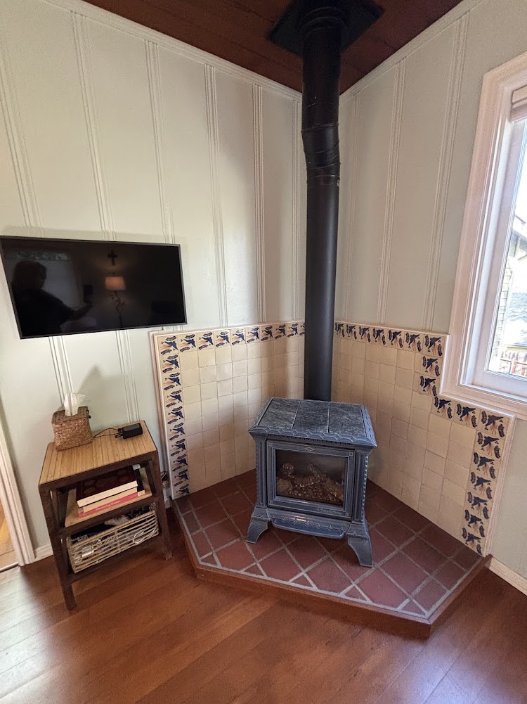 A gas, pot belly stove is thermostat controlled for heating.
