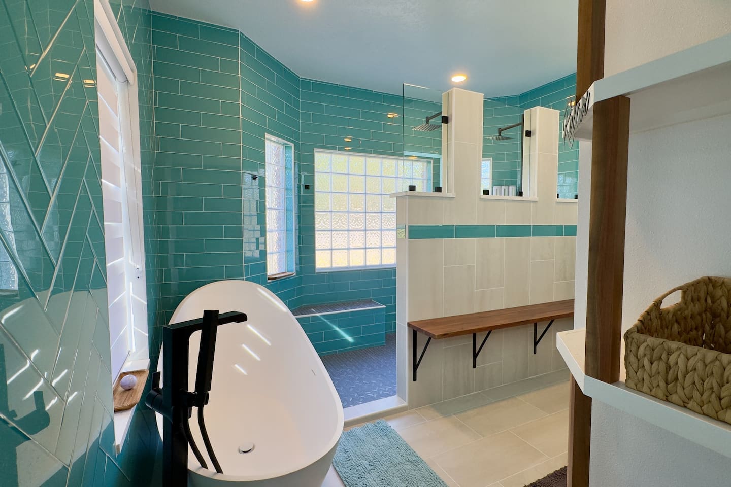 Teal subway tiles and a textured glass block window create a bright, private, and refreshing atmosphere.