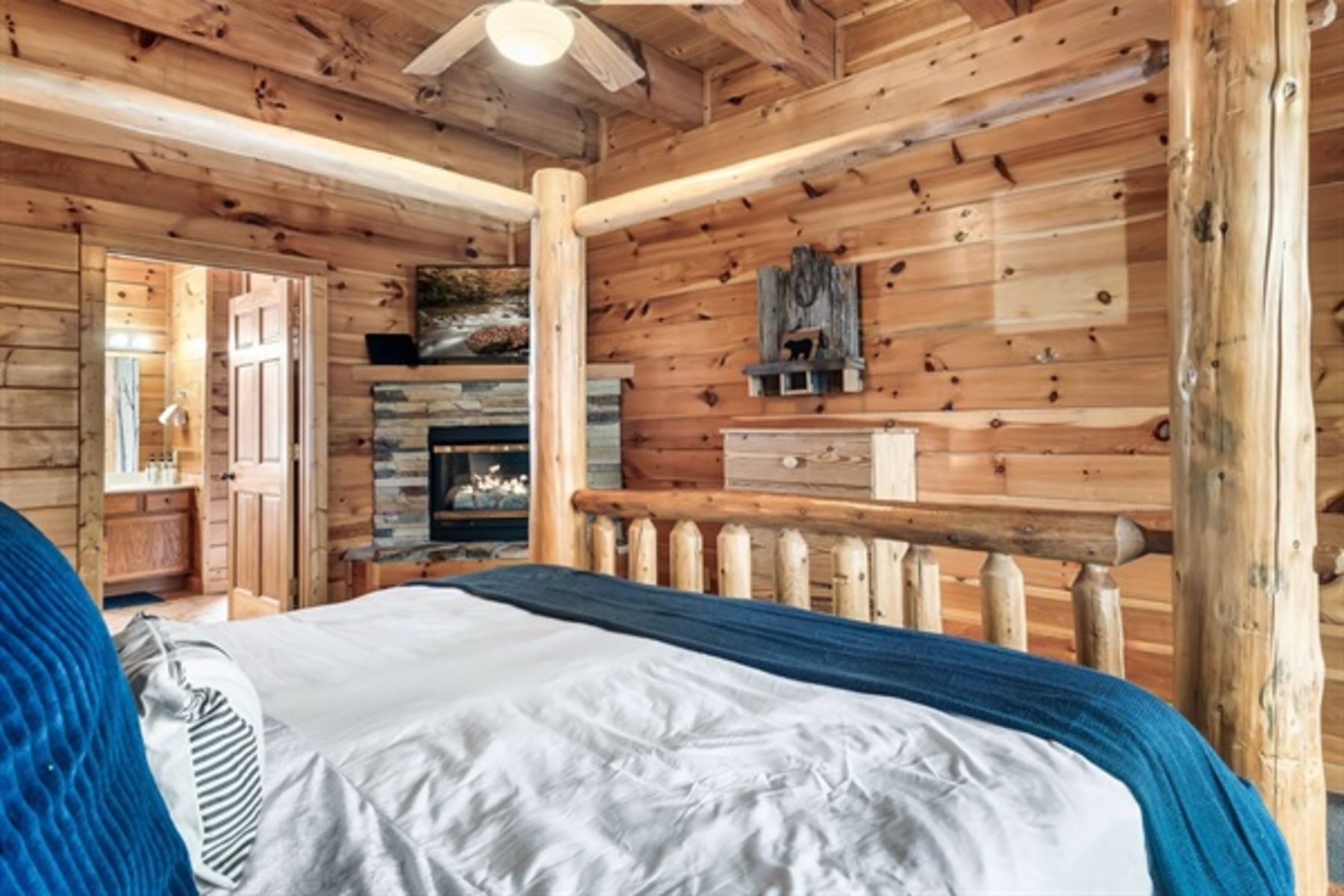 Enjoy the comfort of a main level king bedroom where warm wood tones and a fireplace create a true retreat.