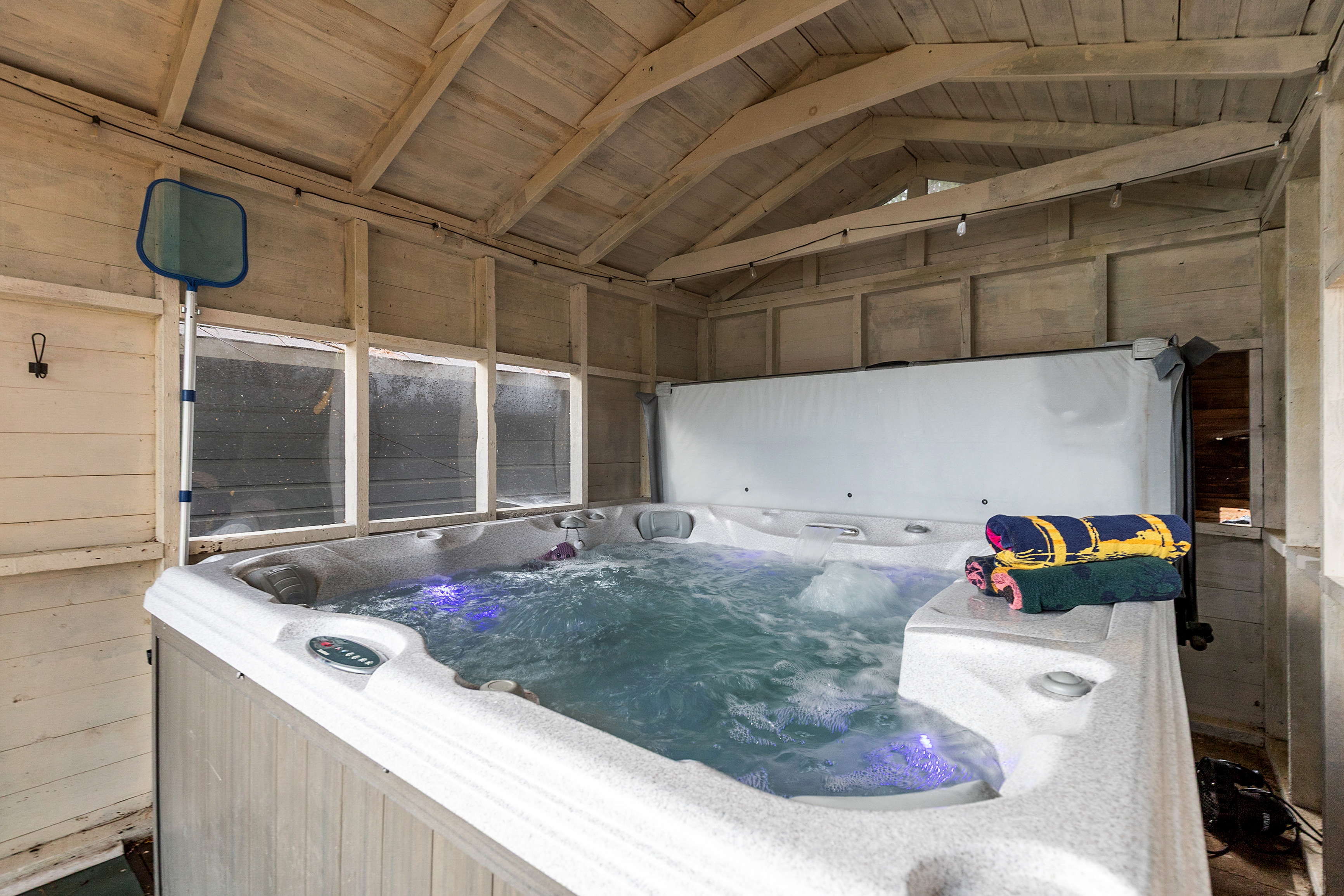 Soak in the hot tub tucked inside its own private enclosure—perfectly covered for year-round relaxation, rain or shine.