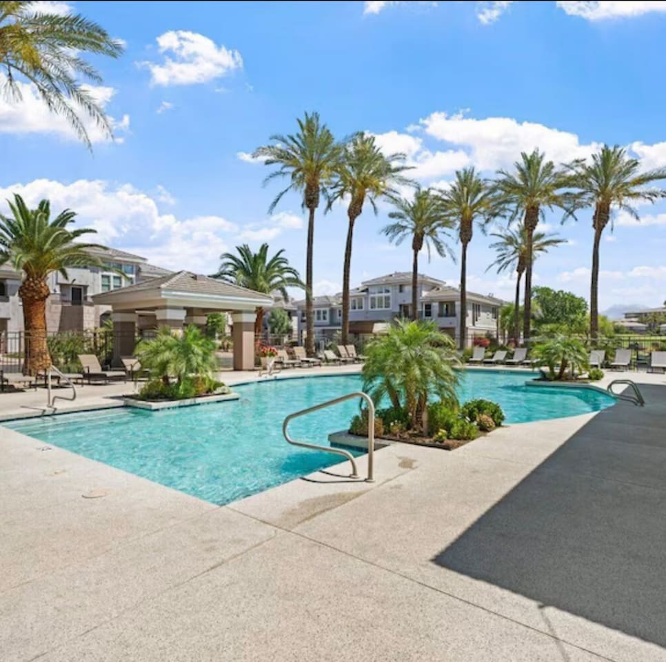 Shared community pool with lounge seating, and shaded areas for relaxing outdoors.
