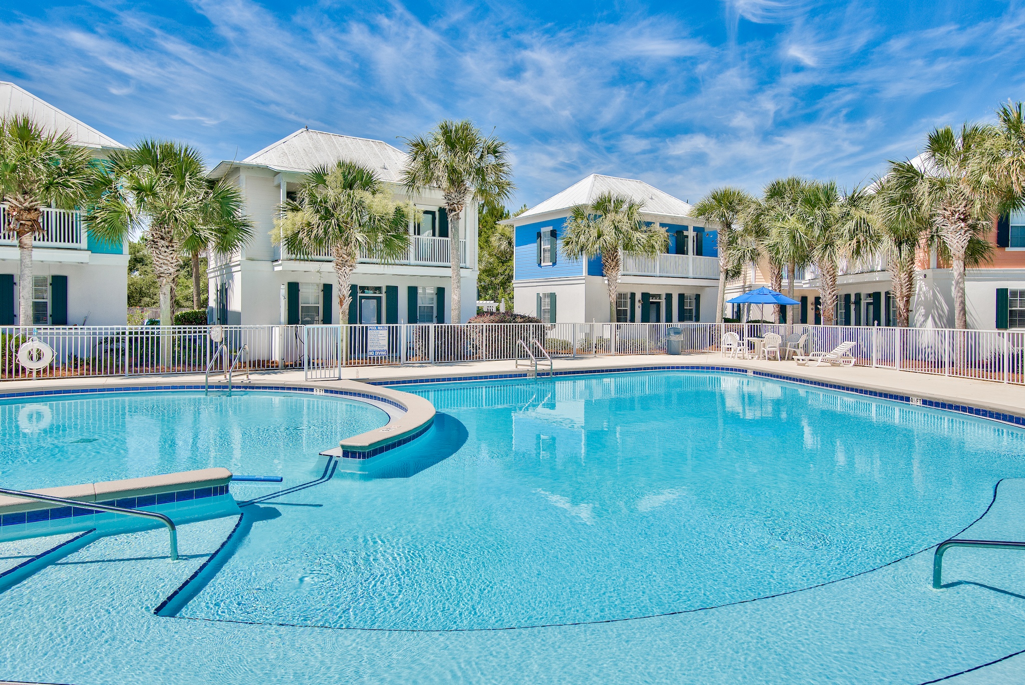 Bungalows at Seagrove shared pool with a curved pool edge, surrounding deck and palm trees.