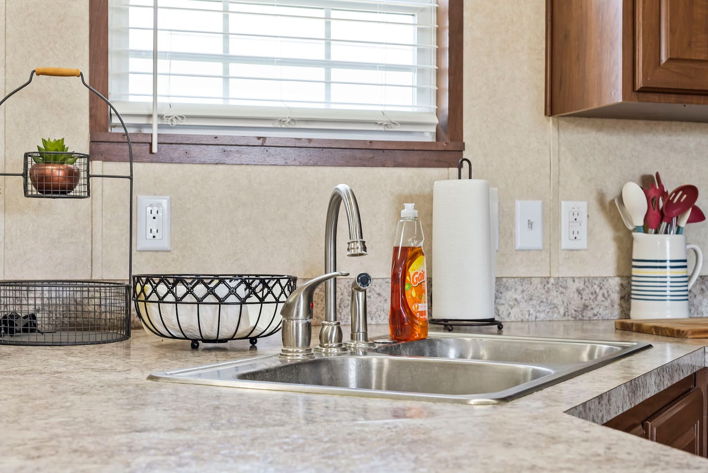 Bright kitchen sink area with natural light, double basin, and plenty of counter space for meal prep and cleanup.