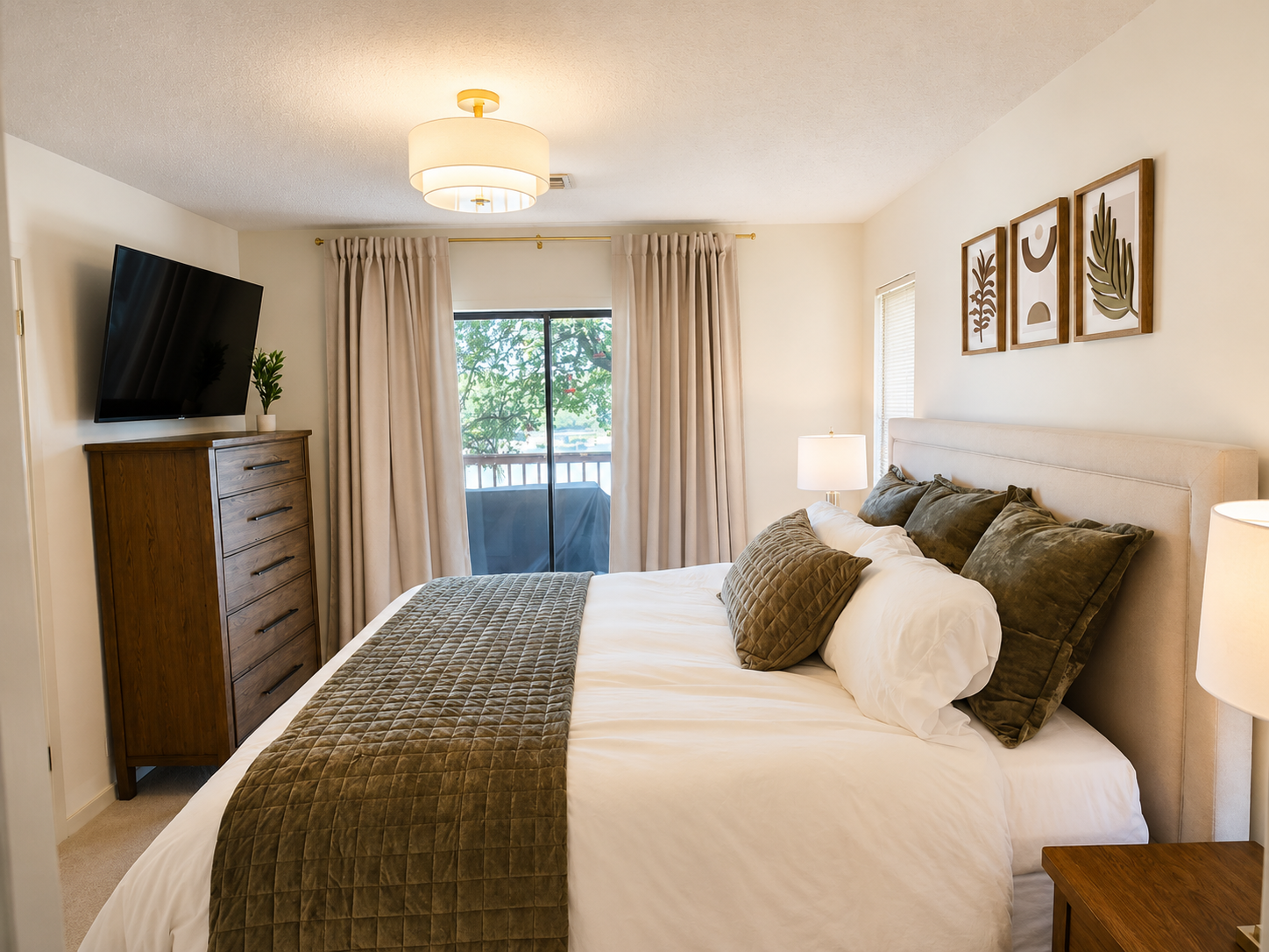 King bedroom with television, direct deck access, and lake view.