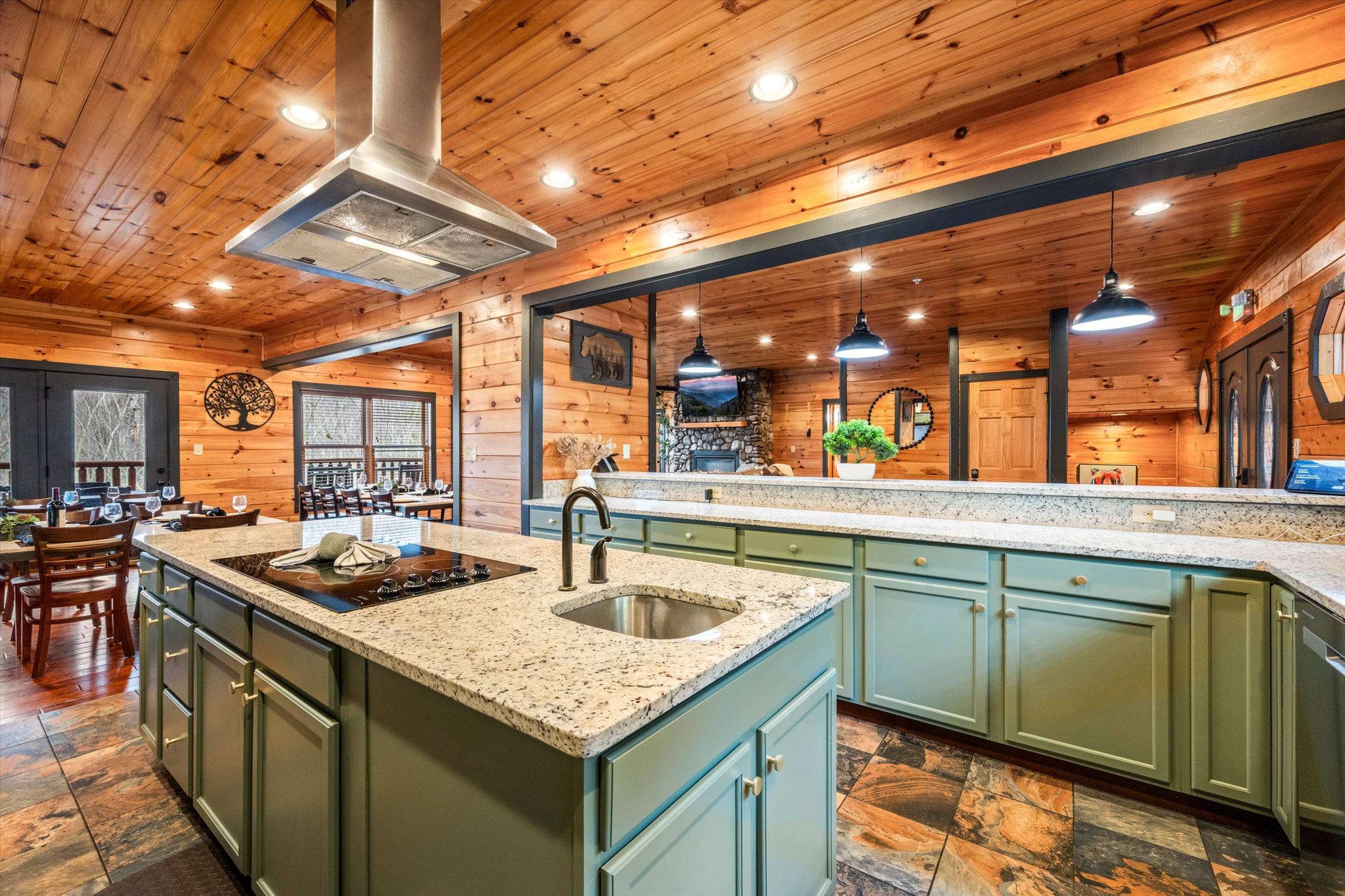 The large kitchen is well stocked and has an induction cooktop, two ovens, two sinks, two dishwashers, and two refrigerators.
