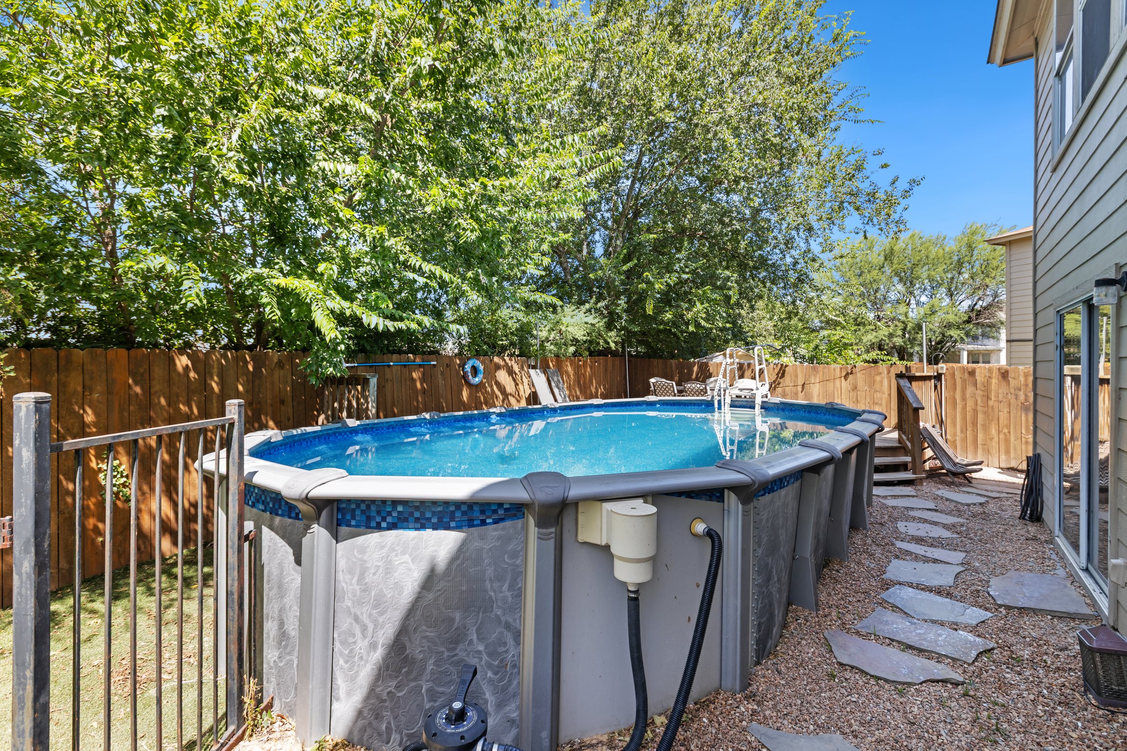 Crystal clear above-ground pool in a fully fenced backyard — private and exclusive to your group. A top amenity for summer family trips and group getaways at this 5BR San Antonio vacation rental.