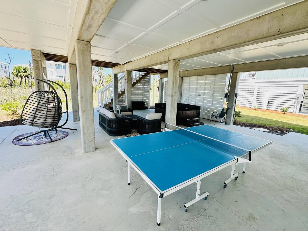 Cozy covered patio with comfortable seating and a ping pong table, perfect for laid-back lounging and friendly competition