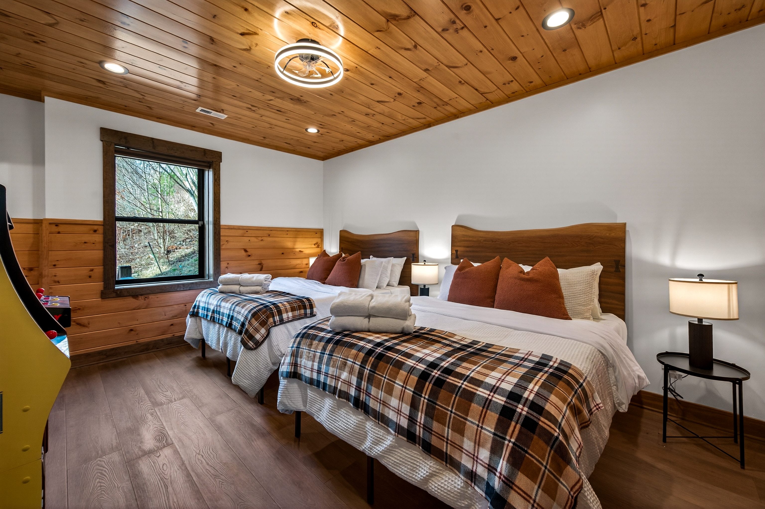 Double Queen Suite – This comfortable bedroom features two queen beds, a large TV, 2 arcades and a private en-suite bathroom with a bathtub, offering a relaxing and fun retreat after a day exploring the Smoky Mountains.